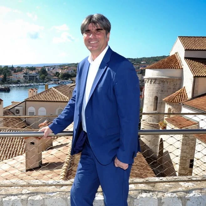 Darijo Vasilić, gradonačelnik Grada Krka, s gradom u pozadini.