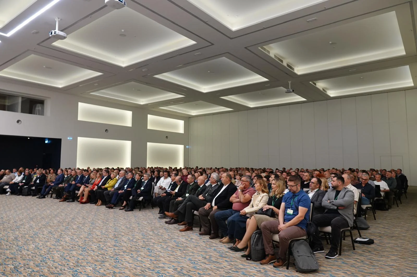 Širok pogled na konferencijsku dvoranu ispunjenu sudionicima.